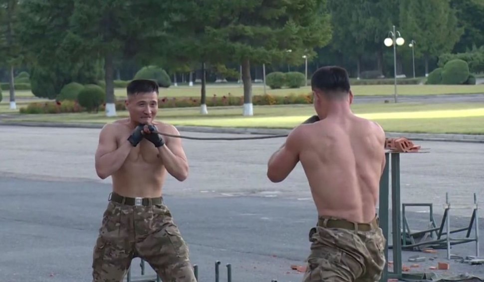 Soldații lui Kim Jong-Un rup lanțuri cu brațele, îndoaie oțel cu gâtul și sparg cărămizi cu pumnii, ca-n filmele cu arte marțiale. Liderul suprem aplaudă, în cele din urmă