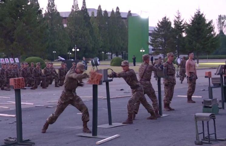 Soldații lui Kim Jong-Un rup lanțuri cu brațele, îndoaie oțel cu gâtul și sparg cărămizi cu pumnii, ca-n filmele cu arte marțiale. Liderul suprem aplaudă, în cele din urmă 731313