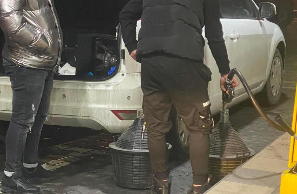 Imaginile care spun totul despre isteria din benzinării. Orice recipient cu capac e bun pentru românii disperați să-și facă stocuri de carburanți 755437