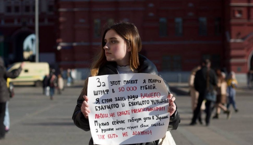 O fată cu pancartă anti-război, luată de poliție în centrul Moscovei | Unii participanți la mega-mitingul lui Putin spun că au fost forțați