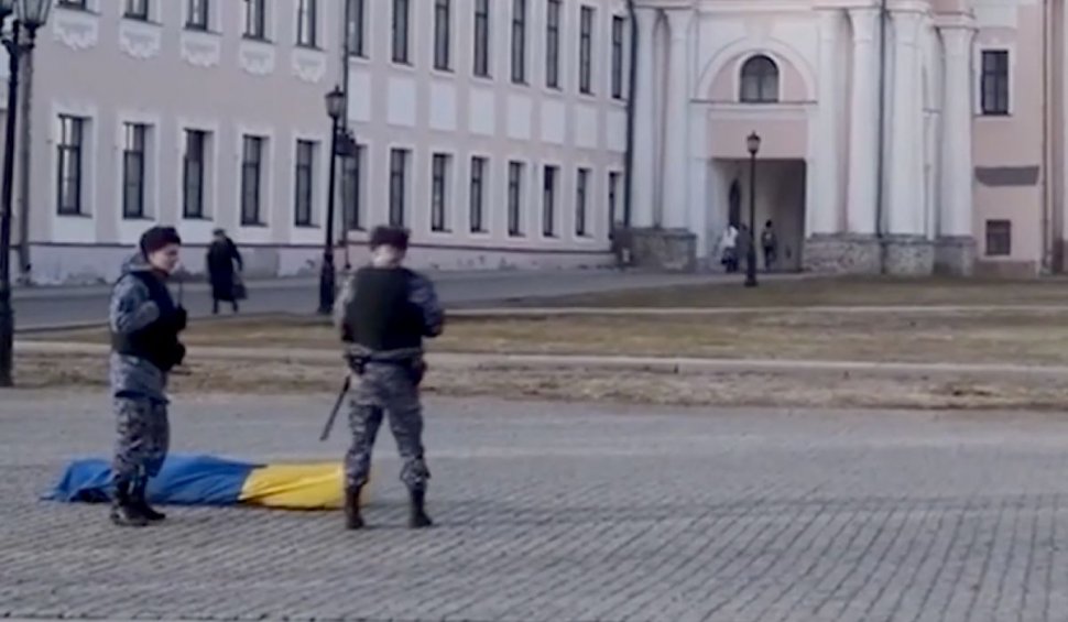 Activist rus înfășurat într-un sac în culorile steagului Ucrainei, protest împotriva crimelor de război