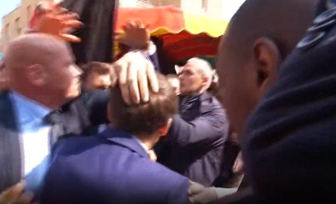 Președintele francez Emmanuel Macron, atacat cu roșii și protejat de agenți cu o umbrelă neagră 764328