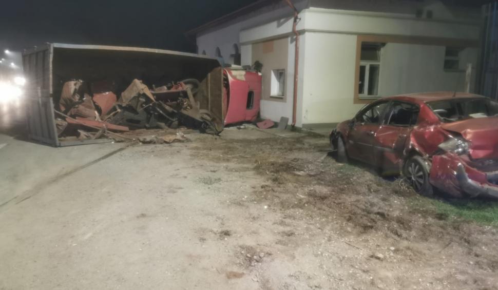 Un autotren încărcat cu fier vechi s-a răsturnat pe o şosea din Giurgiu. O maşină parcată în zonă a fost avariată