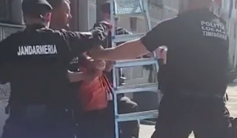 Bărbat săltat de jandarmi după ce a vrut să dea jos steagurile din faţa primăriei din Timişoara: "Toate sunt ilegale"