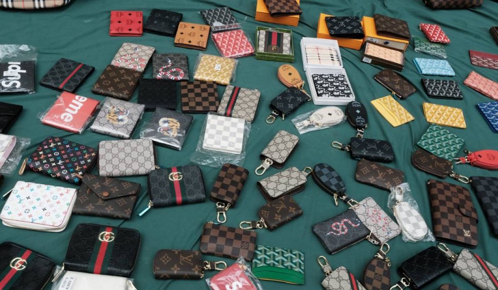 Sute de produse de lux, contrafăcute, vândute de un magazin online, din București. Vânzătorii s-au trezit cu Poliția la ușă