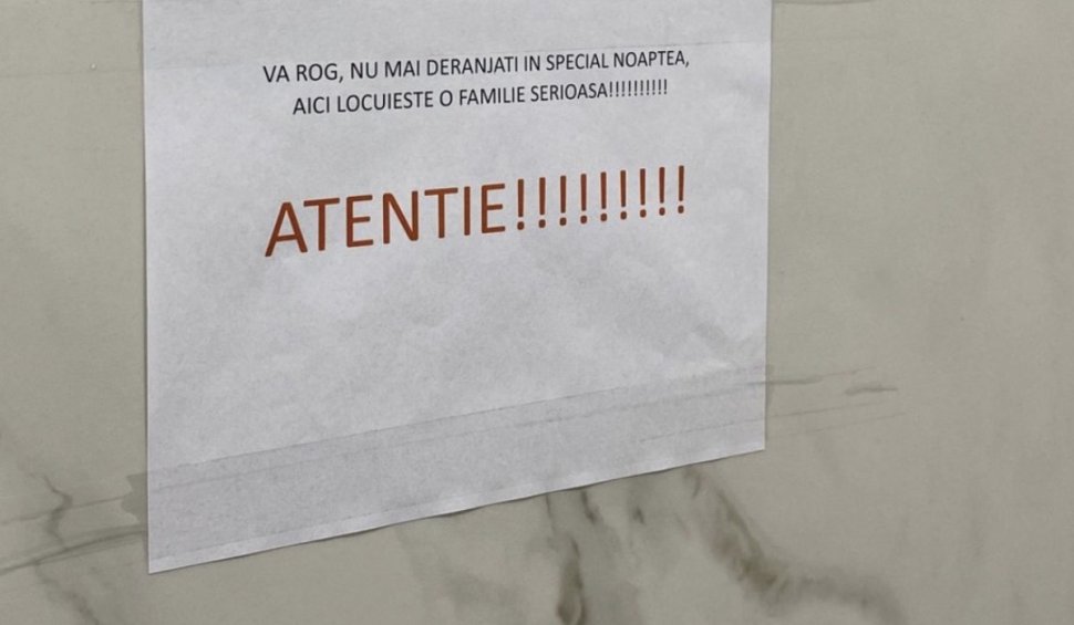Afişul lipit pe uşa unei "familii serioase" de români, agasaţi de clienţii unei vecine care prestează "servicii neortodoxe" 