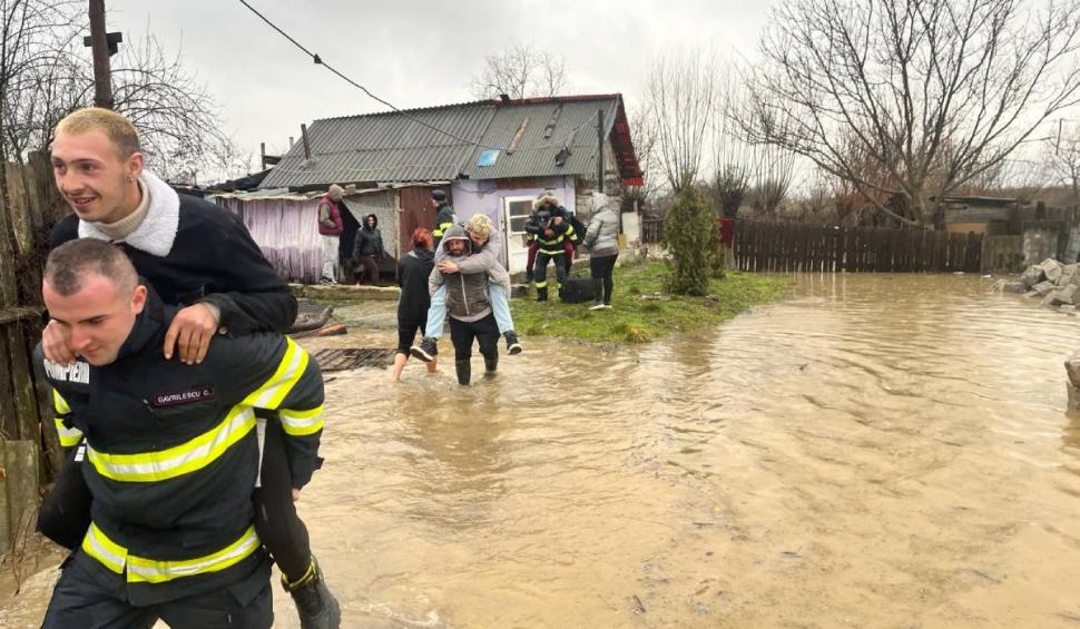 Mai mulți bărbați s-au lăsat "salvați" de apa până la gleznă, urcându-se în spatele pompierilor, în Hunedoara 886455