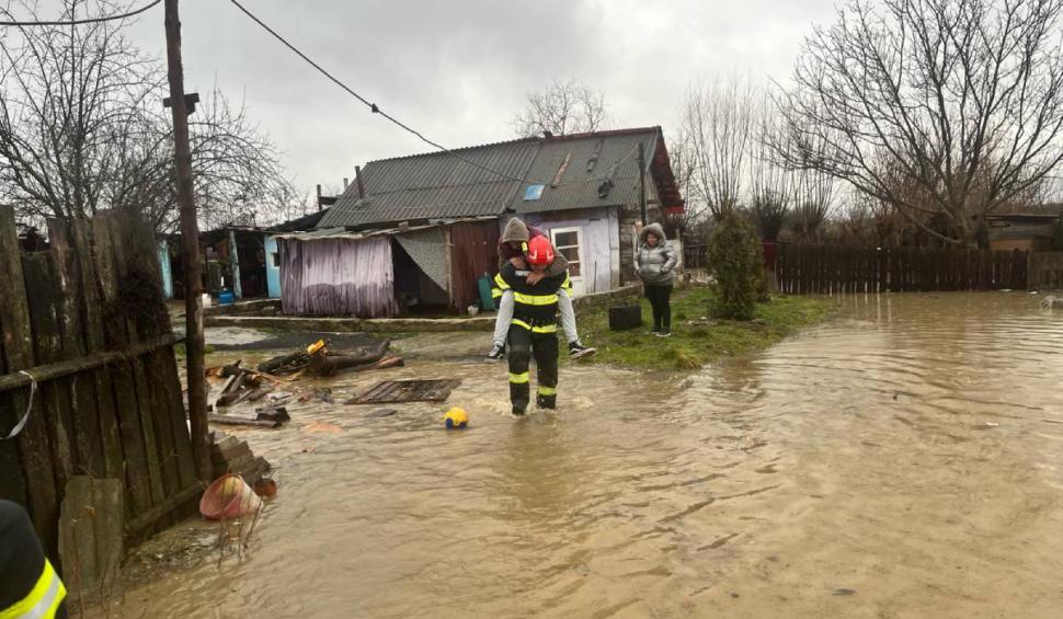 Mai mulți bărbați s-au lăsat "salvați" de apa până la gleznă, urcându-se în spatele pompierilor, în Hunedoara 886457