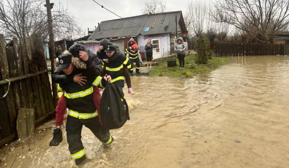 Mai mulți bărbați s-au lăsat "salvați" de apa până la gleznă, urcându-se în spatele pompierilor, în Hunedoara 886458