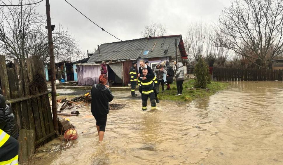 Mai mulți bărbați s-au lăsat "salvați" de apa până la gleznă, urcându-se în spatele pompierilor, în Hunedoara 886463