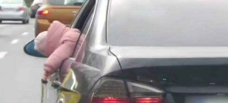Copil ieșit mai mult de jumătate pe geamul mașinii, filmat în traficul din București. Poliția este în alertă  889486