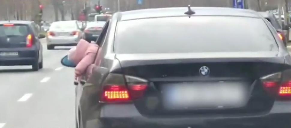 Copil ieșit mai mult de jumătate pe geamul mașinii, filmat în traficul din București. Poliția este în alertă  889488
