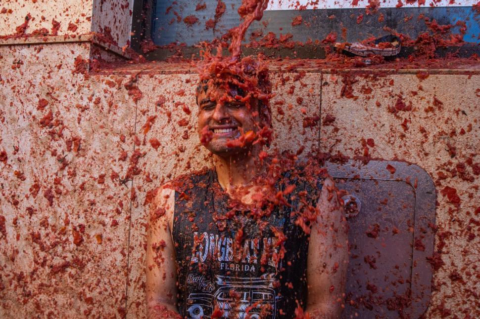 VIDEO Cel mai mare festival la care oamenii plătesc să se bată cu roșii: 22.000 de participanți au colorat străzile din Spania în roșu 920017