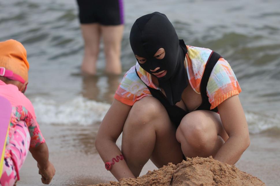 Tot mai mulți oameni vin și pe plajă cu facekini, cagula care protejează de efectele negative ale soarelui 1001733