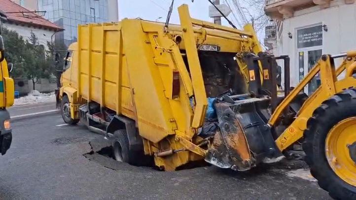 Imagini cu momentul în care o maşină de gunoi a fost "înghiţită" de pământ, la Galaţi, după ce asfaltul s-a surpat 1048650