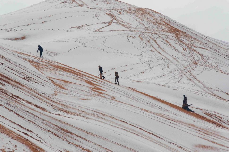 Peisaj SF în Sahara, unde a nins iar zăpada a acoperit dunele de nisip. Localnicii din apropiere s-au dus la derdeluș 1052934