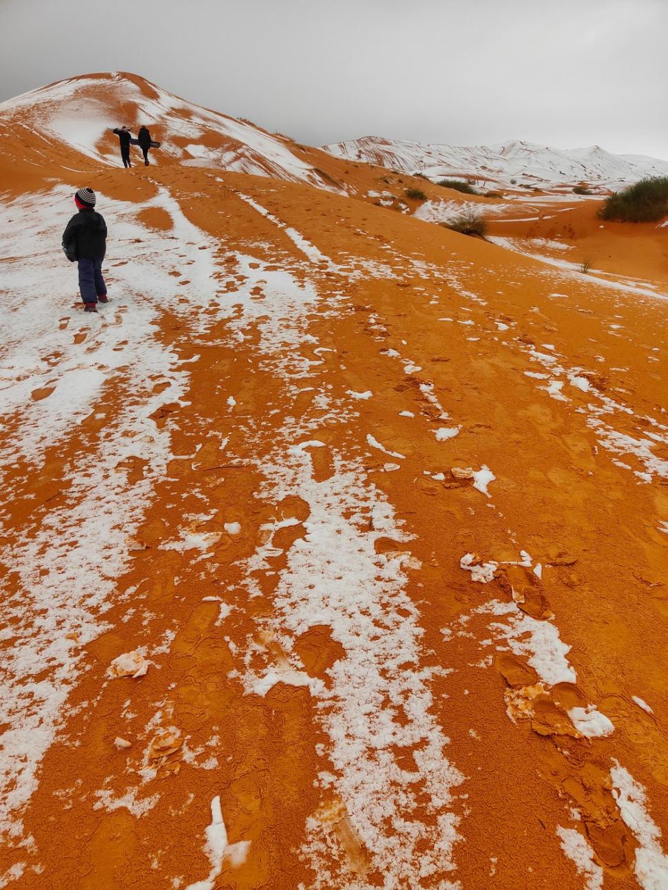 Peisaj SF în Sahara, unde a nins iar zăpada a acoperit dunele de nisip. Localnicii din apropiere s-au dus la derdeluș 1052936