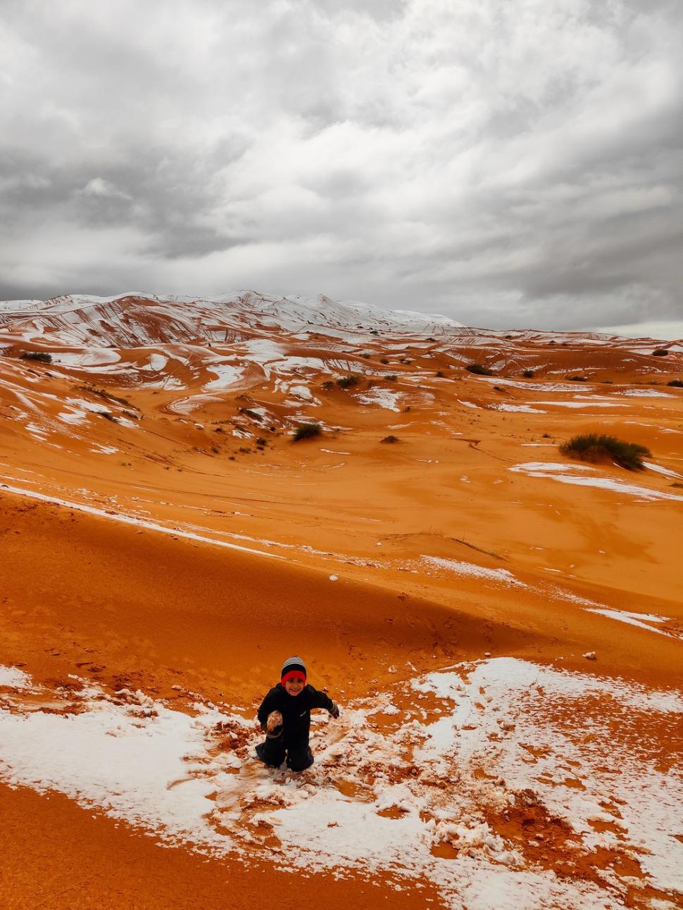 Peisaj SF în Sahara, unde a nins iar zăpada a acoperit dunele de nisip. Localnicii din apropiere s-au dus la derdeluș 1052938