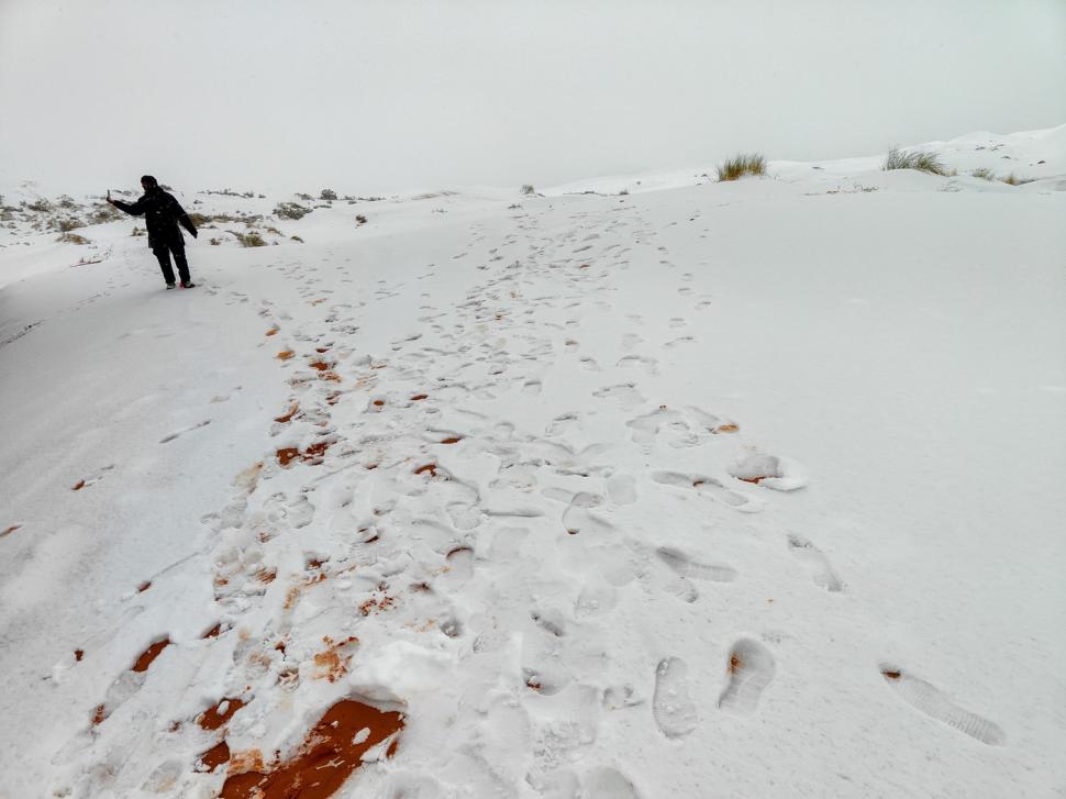 Peisaj SF în Sahara, unde a nins iar zăpada a acoperit dunele de nisip. Localnicii din apropiere s-au dus la derdeluș 1052939