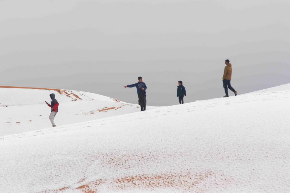 Peisaj SF în Sahara, unde a nins iar zăpada a acoperit dunele de nisip. Localnicii din apropiere s-au dus la derdeluș 1052943