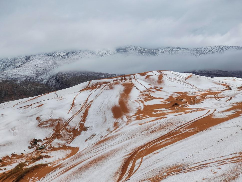 Peisaj SF în Sahara, unde a nins iar zăpada a acoperit dunele de nisip. Localnicii din apropiere s-au dus la derdeluș 1052944