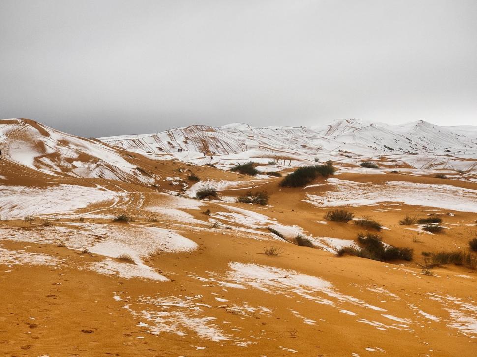 Peisaj SF în Sahara, unde a nins iar zăpada a acoperit dunele de nisip. Localnicii din apropiere s-au dus la derdeluș 1052945
