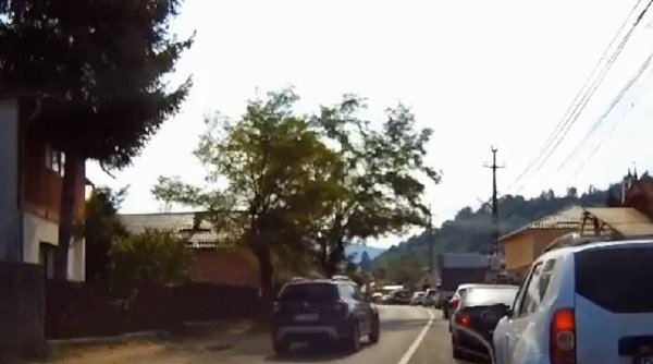 Șofer filmat în timp ce depășește o coloană de mașini, în curbă. Reacția polițiștilor care se aflau în zonă