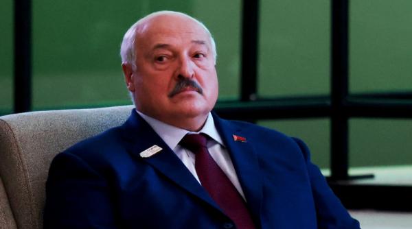Momentul în care Aleksandr Lukaşenko este împins şi cade pe gheaţă în timpul unui meci de hochei