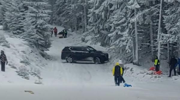 Momentul în care un turist intră cu maşina pe pârtia din Parâng, printre copiii care se dădeau cu sania