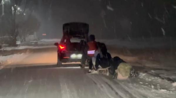 Patru tineri au fost filmaţi când erau trași cu săniile de o maşină pe un drum public din judeţul Timiş 