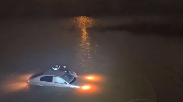 Doi poliţişti au salvat o şoferiţă care a căzut cu maşina în apele îngheţate ale râului Jiu. Imagini de la operaţiunea dramatică