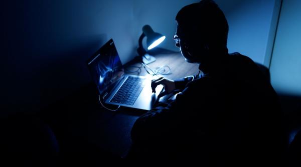 Un tânăr român a strâns 300.000 de euro folosind laptopul mamei sale pentru a lansa atacuri cibernetice. Ce făcea când a intrat poliția