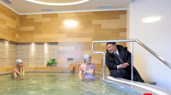 imbracat in pufoaica kim rade cu pofta impreuna cu femei in costum de baie dintr o piscina fierbinte imagini comice in coreea de nord