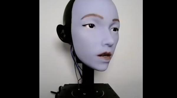 fata infioratoare a unui robot umanoid invata sa si miste buzele mai uman in timp ce se priveste in oglinda apoi se uita pe youtube