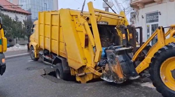 Imagini cu momentul în care o maşină de gunoi a fost "înghiţită" de pământ, la Galaţi, după ce asfaltul s-a surpat