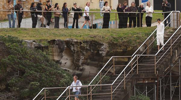 un barbat echipat pentru o baie in mare a nimerit fara sa vrea in mijlocul unei prezentari de moda
