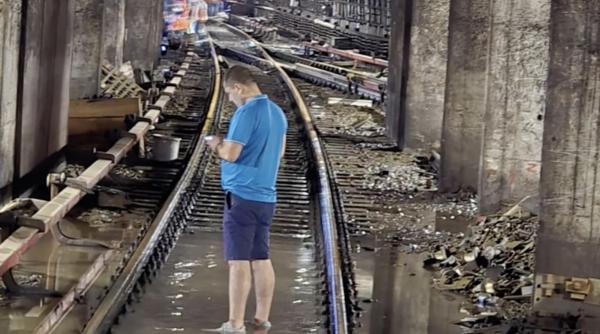 radu miruta surprins in timp ce se plimba descult prin apa care a inundat statia de metrou victoriei dupa codul rosu din bucuresti