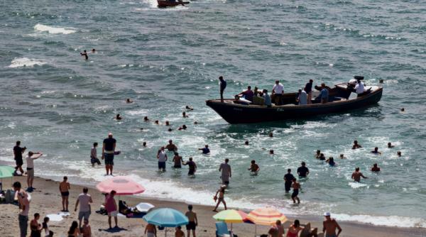 turistii de pe o plaja din spania au luat o la fuga cand 60 de migranti cu o barca au luat cu asalt locul
