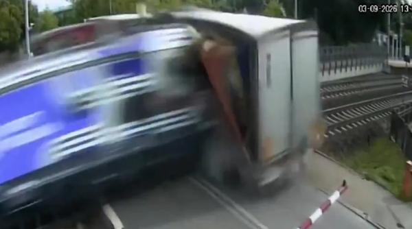 VIDEO Un camion a fost blocat pe șine de bariere, dar șoferul n-a vrut să le spargă și nu a mai reușit să evite trenul