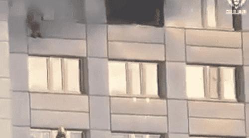 Momentul dramatic în care o femeie sare de la etajul 11, în braţele pompierului, pentru a scăpa de incendiu