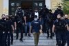 Un criminal din Grecia a fost dus la tribunal cu o vestă antiglonț și escortă înarmată, după ce și-a asfixiat soția și spânzuat câinele 712953